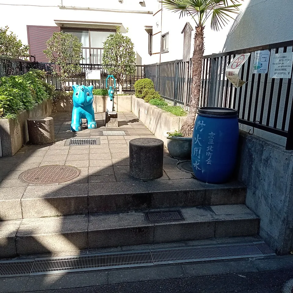 A small neighborhood corner in Kyojima with a blue elephant-shaped feature and a hand pump.