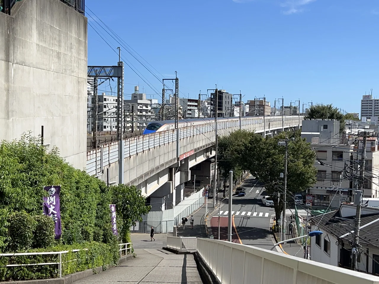 An E7 Series Shinkansen entering Akabanedai Tunnel below Akabane Hachiman Shrine