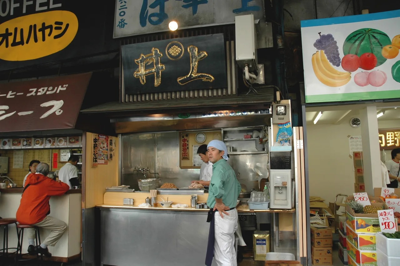 A standing ramen counter in the Tsukiji outer market with staff working behind an open kitchen