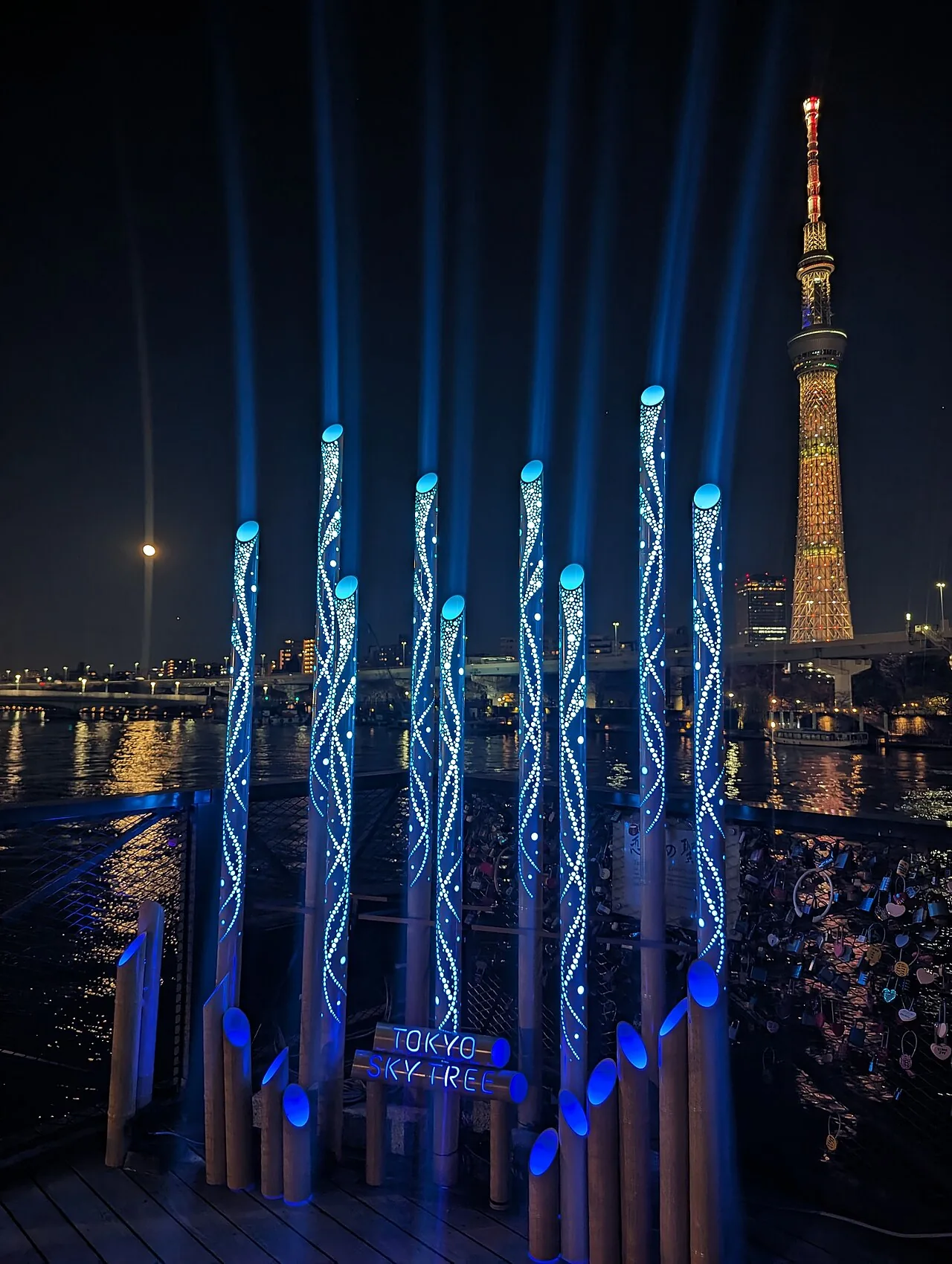 Sumida River Walk pedestrian bridge at night with Tokyo Skytree behind