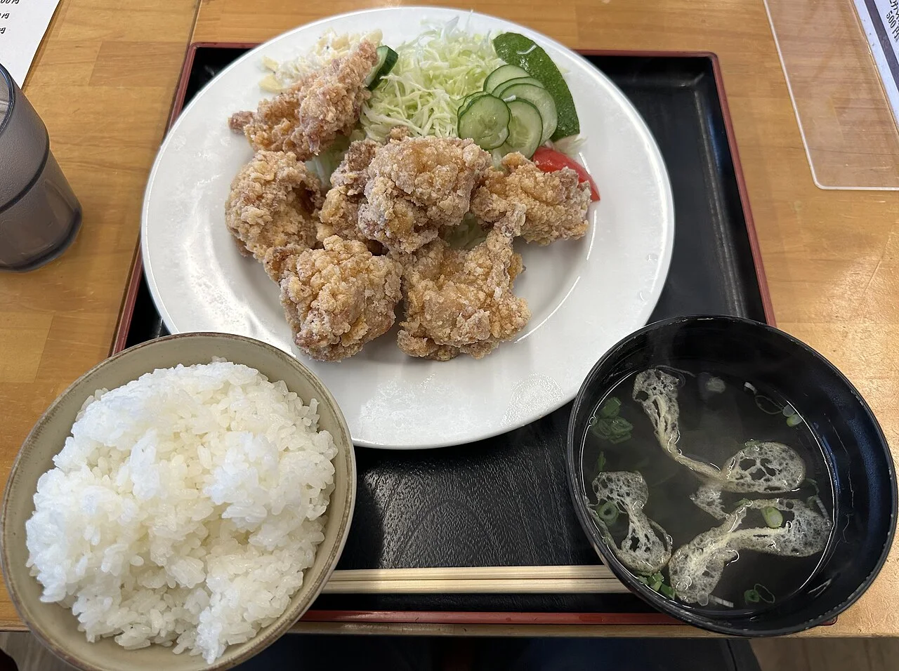 A karaage set meal on a tray with a bowl of rice and a bowl of clear soup
