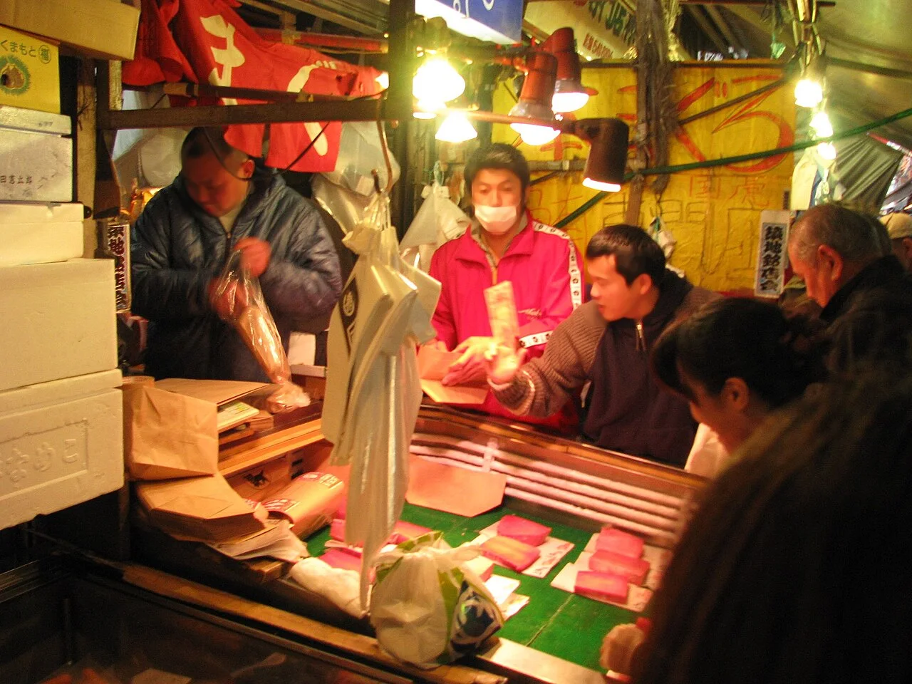 A tuna stall in the Tsukiji outer market with customers being served across the counter